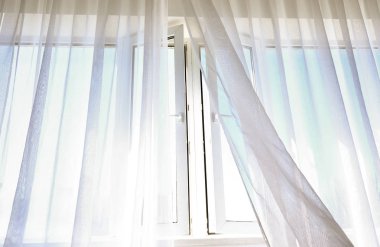 Odada hafif perdeler bulunan açık pencere