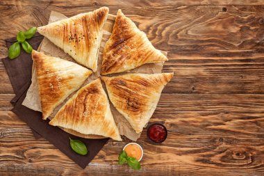 Ahşap masada soslar ile lezzetli samosas