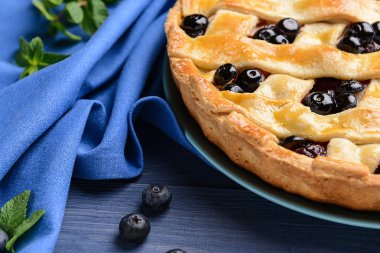 Renkli ahşap masada lezzetli yaban mersini pasta