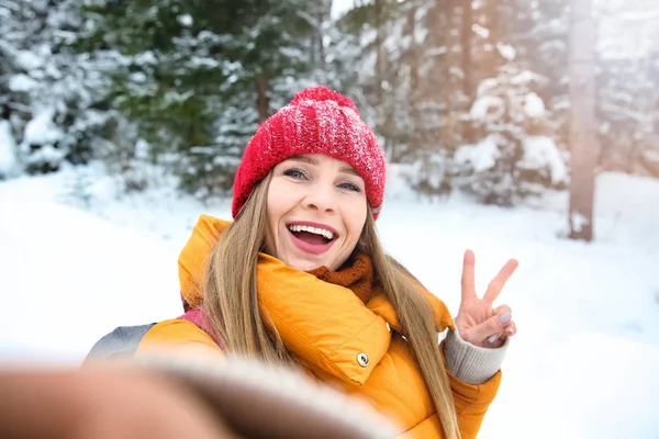Beautiful woman taking selfie in winter forest — Stock Photo, Image