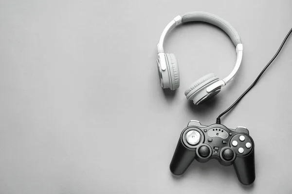 Modern game pad and headphones on grey background — Stock Photo, Image