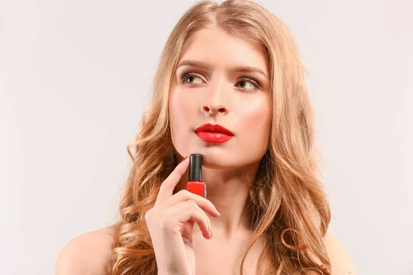 Beautiful young woman with bright nail polish on light background — Stock Photo, Image