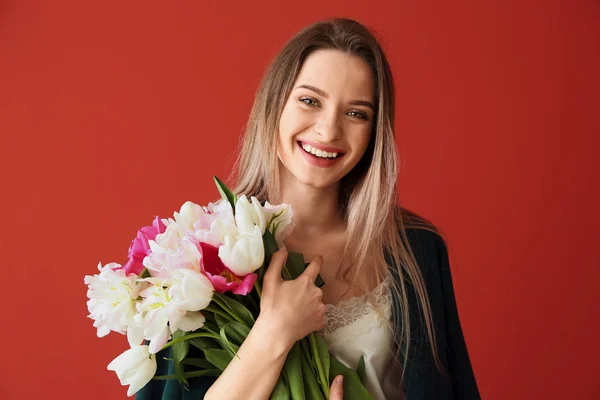 Young woman with bouquet of beautiful tulips on color background — Stock Photo, Image