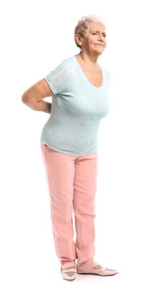 Mulher idosa que sofre de dor nas costas no fundo branco — Fotografia de Stock