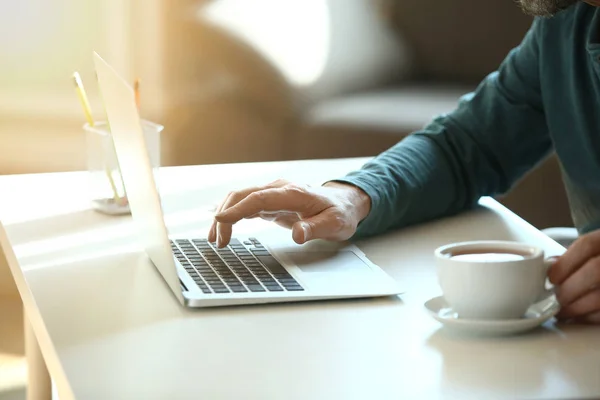 Schöner reifer Mann mit Laptop zu Hause — Stockfoto