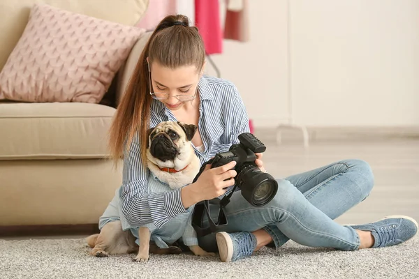 Teenage girl with cute pug dog and photo camera at home — Stock Photo, Image