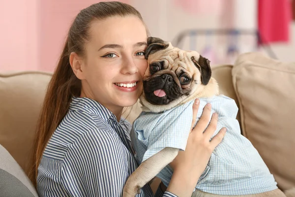 Девочка-подросток с милой собакой-мопсом дома — стоковое фото