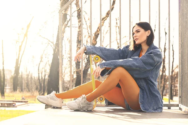 Elegante mujer joven con monopatín al aire libre —  Fotos de Stock