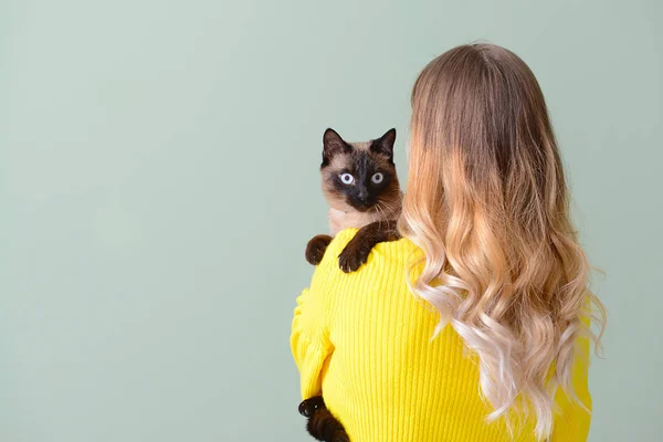 Jovem mulher com gato tailandês bonito no fundo de cor — Fotografia de Stock