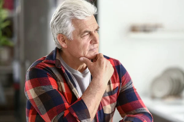 Portrait of thoughtful senior man in kitchen at home — Stock Photo, Image