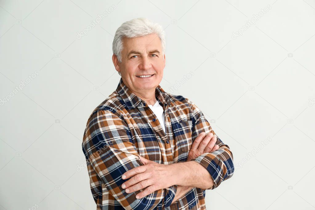 Portrait of handsome senior man on light background