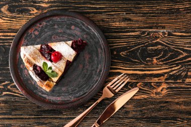 Ahşap masa üzerinde lezzetli kiraz pasta dilim ile Tabak