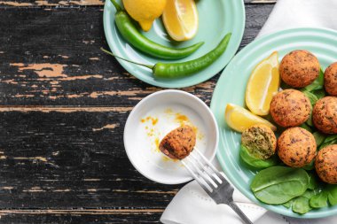 Ahşap masa üzerinde sos ile lezzetli falafel topları