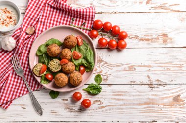 Ahşap masa üzerinde lezzetli falafel topları ile Plaka