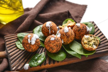 Ahşap tahta üzerinde lezzetli falafel topları ve ıspanak