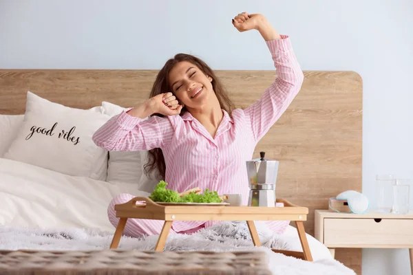 Beautiful young woman having breakfast in bed — Stock Photo, Image