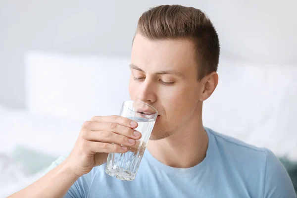 Handsome man drinking water at home — Stock Photo, Image