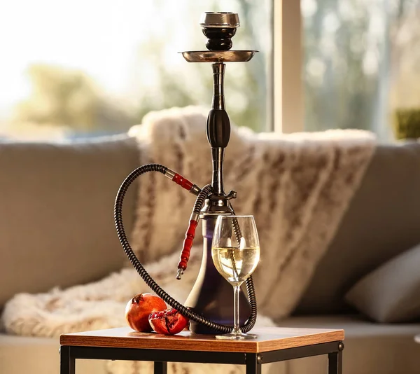 Hookah, pomegranate and glass of alcohol on table in room — Stock Photo, Image