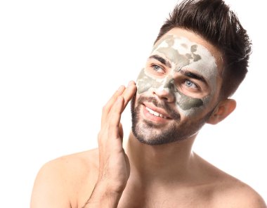 Handsome man with clay mask on his face against white background clipart