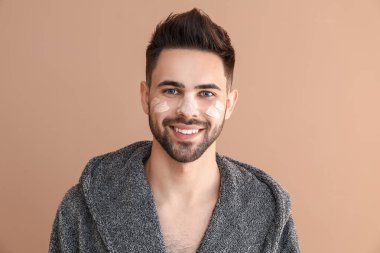 Renk arka plan karşı yüzünde kozmetik kil ile Yakışıklı adam