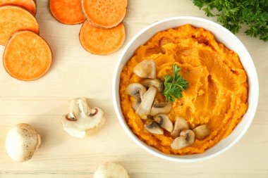 Ahşap arka plan üzerinde tatlı patates püresi ve mantar ile Bowl