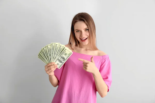 Mujer joven feliz con dinero sobre fondo blanco —  Fotos de Stock