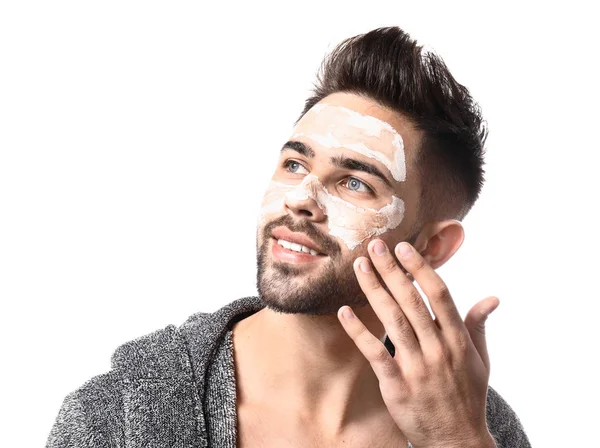 Hombre guapo con máscara de arcilla en su cara contra fondo blanco — Foto de Stock