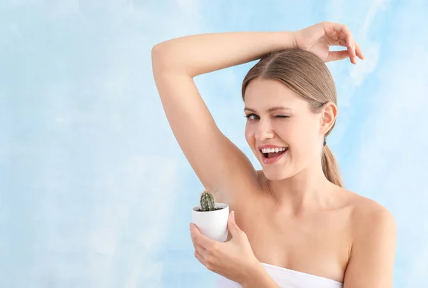 Beautiful young woman with cactus on light background. Depilation concept — Stock Photo, Image