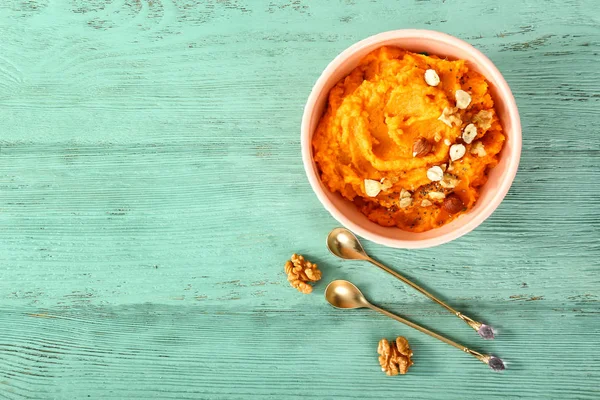 Cuenco con puré de batata y nueces sobre fondo de madera — Foto de Stock