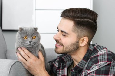 Evde sevimli komik kedi ile genç adam