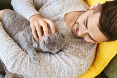 Evde sevimli komik kedi ile genç adam