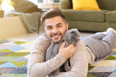 Evde sevimli komik kedi ile genç adam