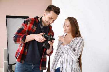 Genç model stüdyoda onun resimleri gösteren erkek fotoğrafçı