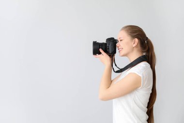 Hafif arka planda genç bayan fotoğrafçı