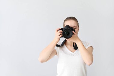 Hafif arka planda genç bayan fotoğrafçı