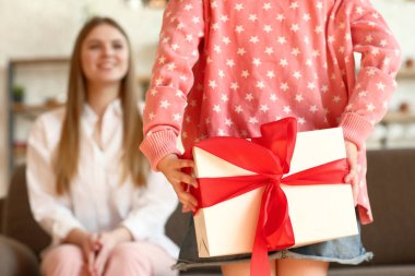 Küçük kızı evde arkasında annesi için hediye gizleme