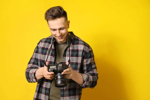 Jonge mannelijke fotograaf op kleur achtergrond — Stockfoto