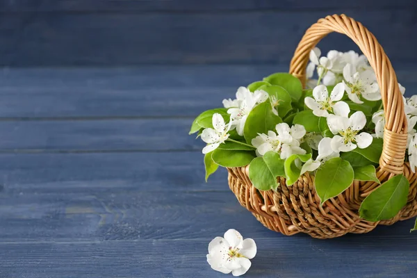 Panier en osier avec de belles fleurs sur une table en bois — Photo