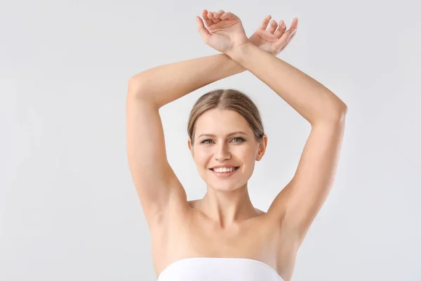 Beautiful young woman after laser hair removal procedure on light background — Stock Photo, Image