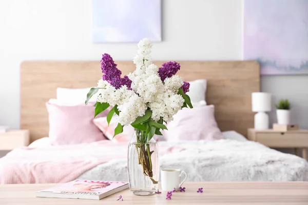 Vaso con bellissimi fiori lilla sul tavolo in camera da letto — Foto Stock