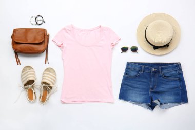 Beyaz arka planda aksesuarları olan şık kadın kıyafetleri.