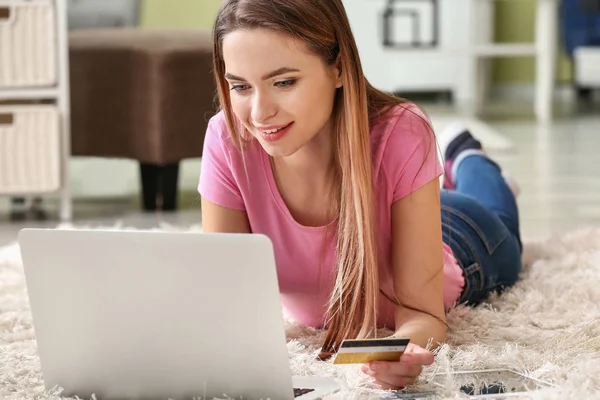 Jonge vrouw met creditcard thuis online winkelen — Stockfoto