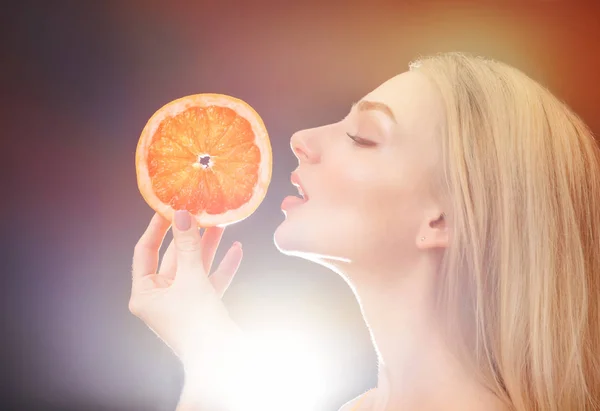 Mulher bonita com toranja fresca no fundo escuro — Fotografia de Stock