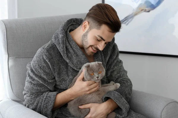 Giovane uomo con simpatico gatto divertente a casa — Foto Stock