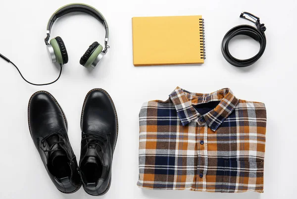 Vêtements masculins élégants avec écouteurs et cahier sur fond blanc — Photo