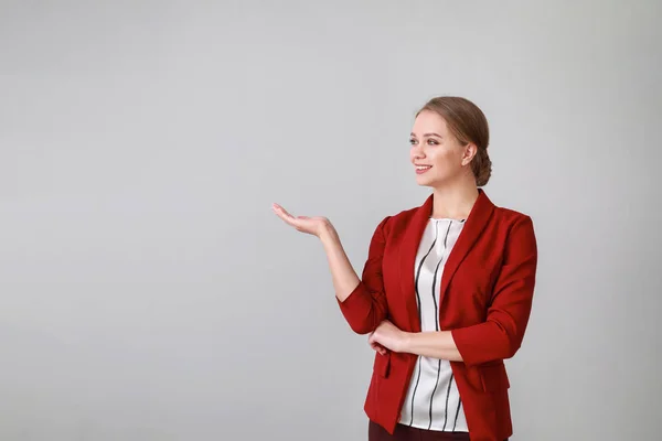 Retrato de mujer de negocios mostrando algo sobre fondo claro —  Fotos de Stock