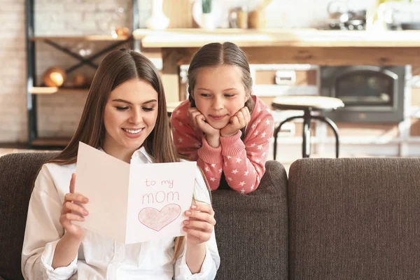 Gelukkige moeder ontvangen wenskaart van haar kleine dochter thuis — Stockfoto