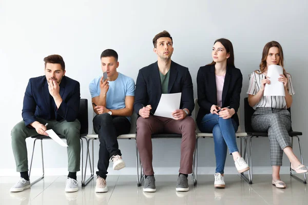 Jóvenes esperando entrevista de trabajo en interiores —  Fotos de Stock