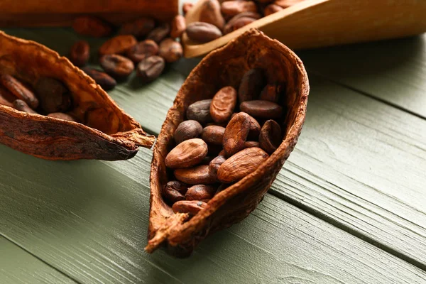 Ahşap arka planda kakao çekirdekleri ile Pod