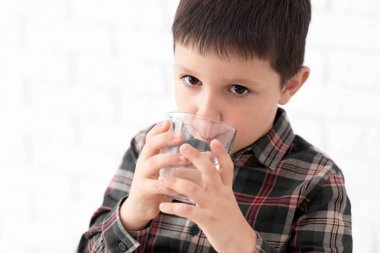 Küçük çocuk hafif arka plan üzerinde tatlı su içme